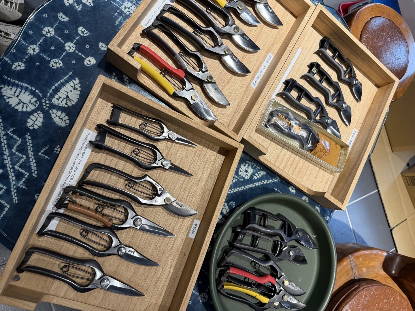 Pruning shears laid out in wooden trays, seen from above