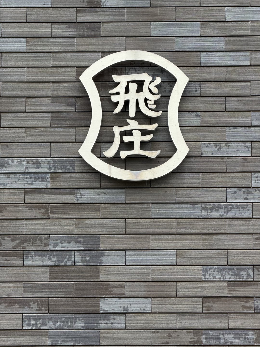 The Tobisho trade-name plate on a tiled wall