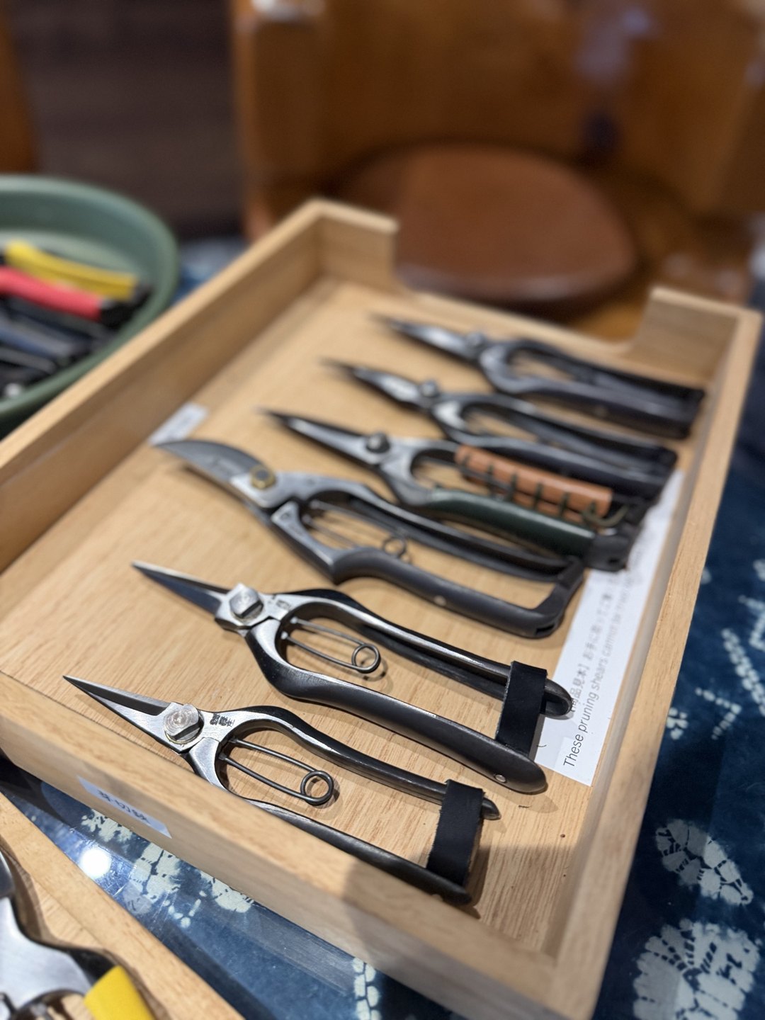 A tray of slim shears lined up in a row
