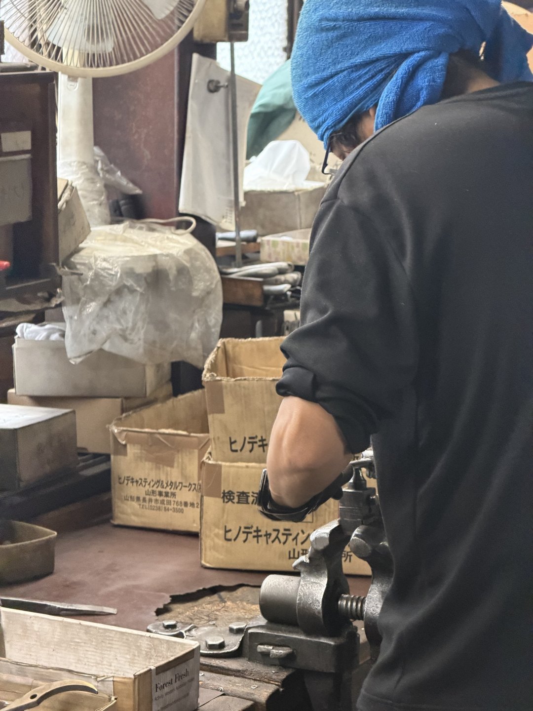 A craftsperson at a bench seen from behind
