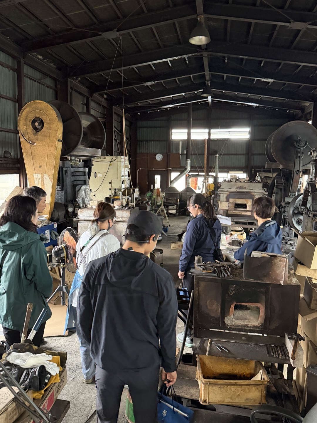 Visitors gathered near the press plus furnace
