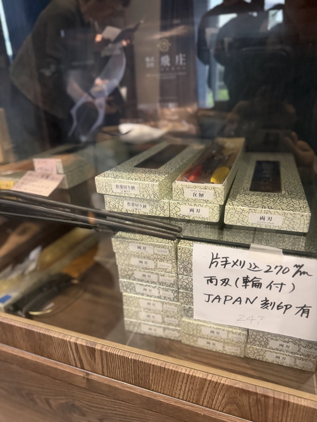 A glass display case holding boxed shears