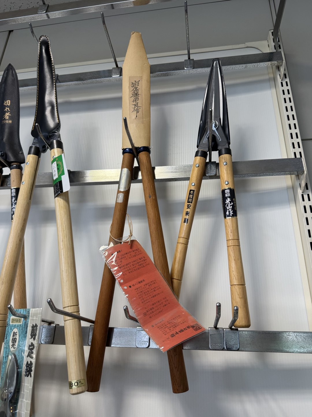 Trimming shears with wooden handles hanging on a rail