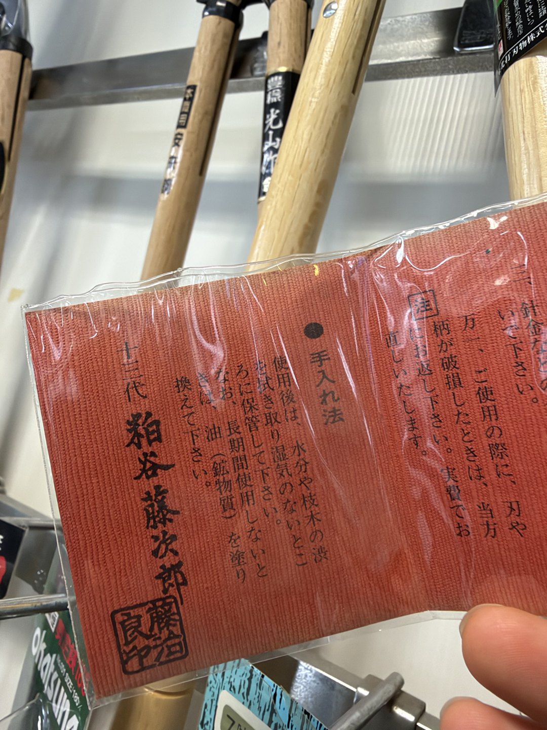 A red care tag with a maker's name