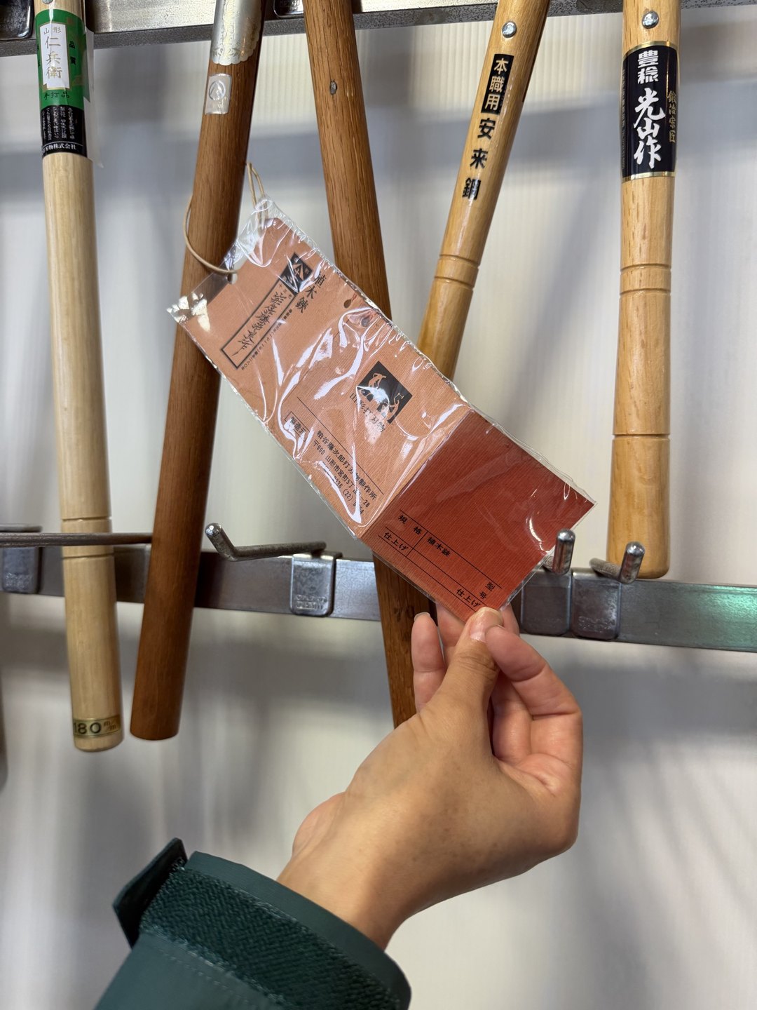 A hand holding a tag hung on a trimming shear